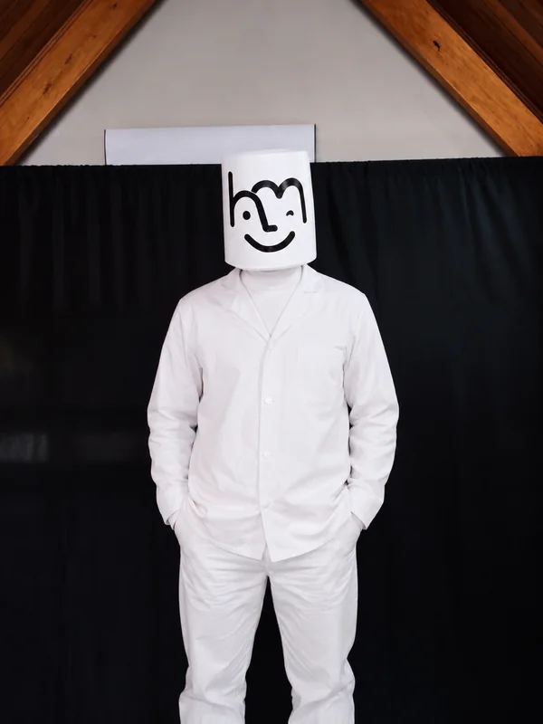 Mark de frente con su máscara blanca y vestuario blanco